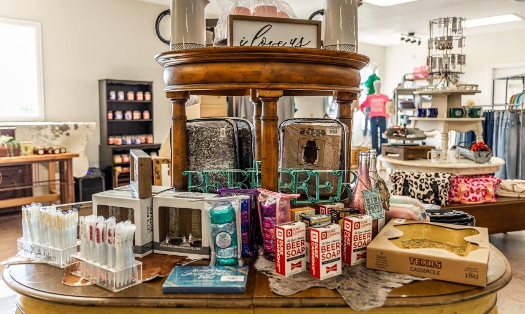 An assortment of products on a table, lotions, soaps, mugs and gifts