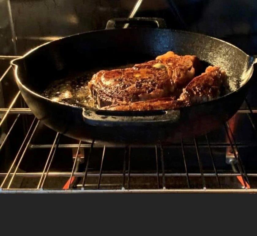 Locally sourced beef cooking in an iron skilled in the oven
